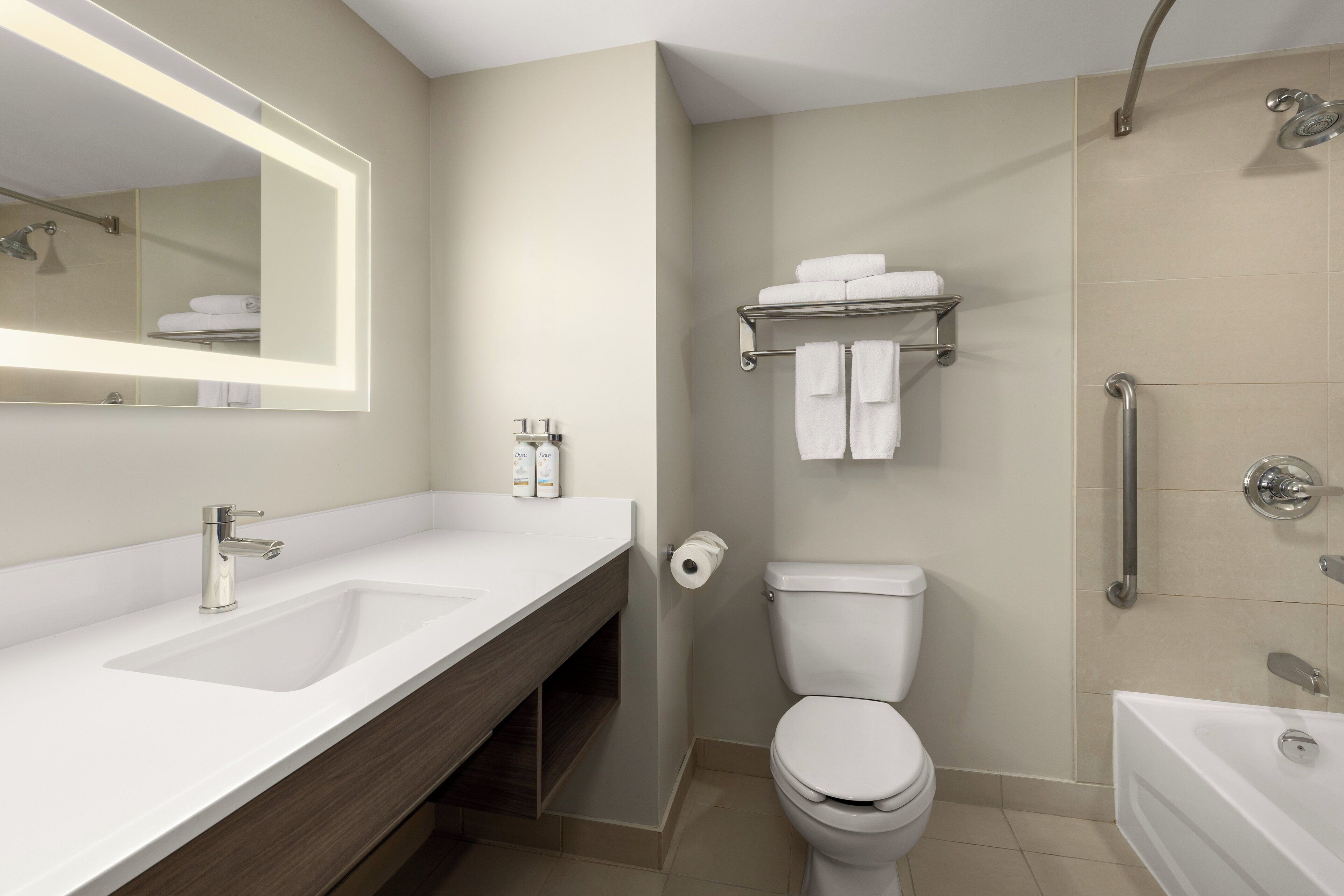 Ein modernes Badezimmer mit großem Spiegel, zwei Waschbecken, Toilette, Dusche und Badewanne.