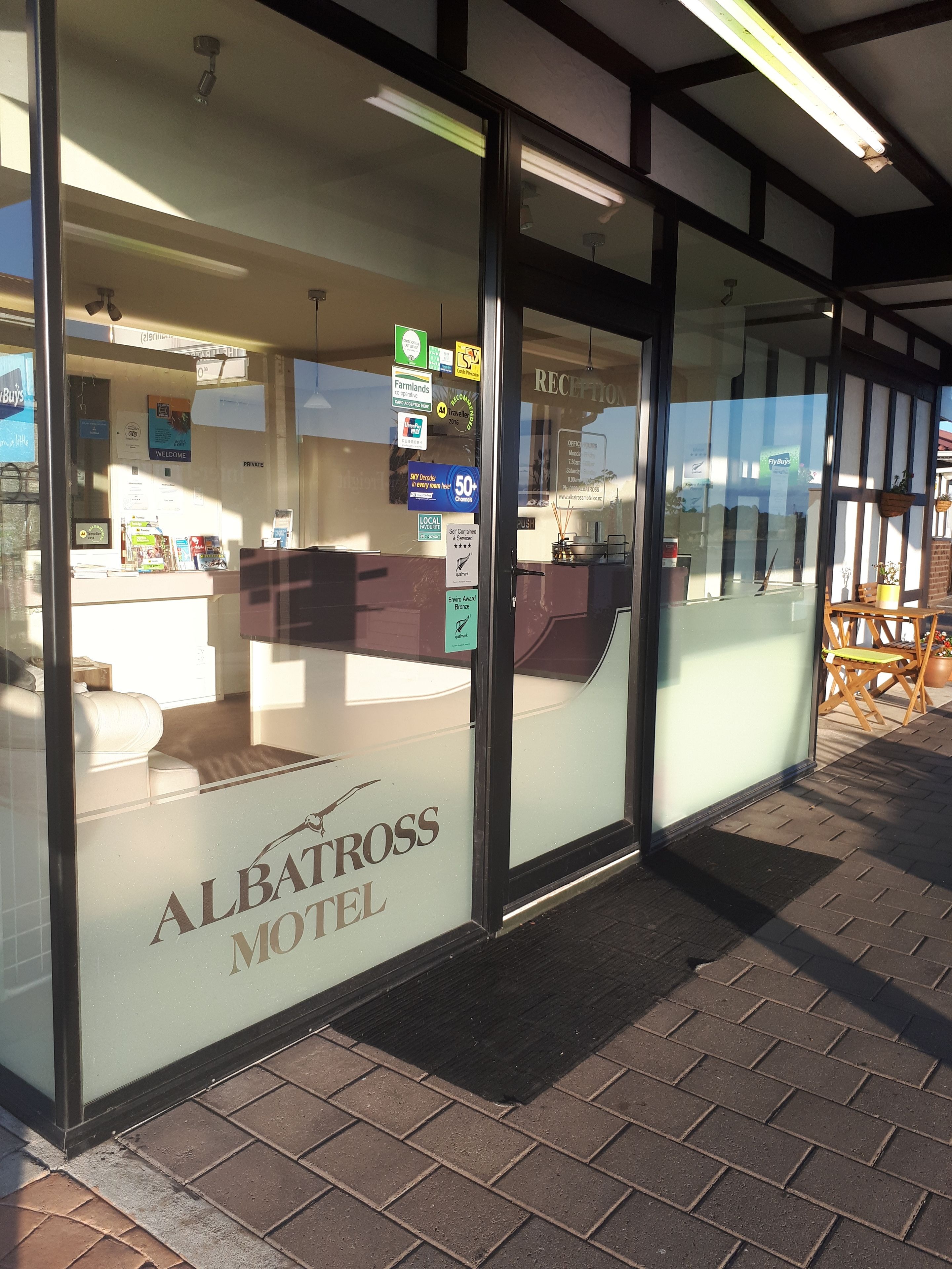 Exterior del motel Albatross con una recepción, un cartel que indica que es un establecimiento privado y vistas de la calle.