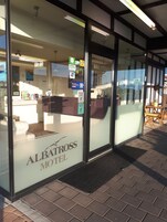Exterior del motel Albatross con una recepción, un cartel que indica que es un establecimiento privado y vistas de la calle.