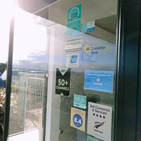 Una ventana con varios premios de viajes y hotelería, incluyendo una insignia de 'Favorito Local' y un letrero que indica 'Más de 50 canales'.