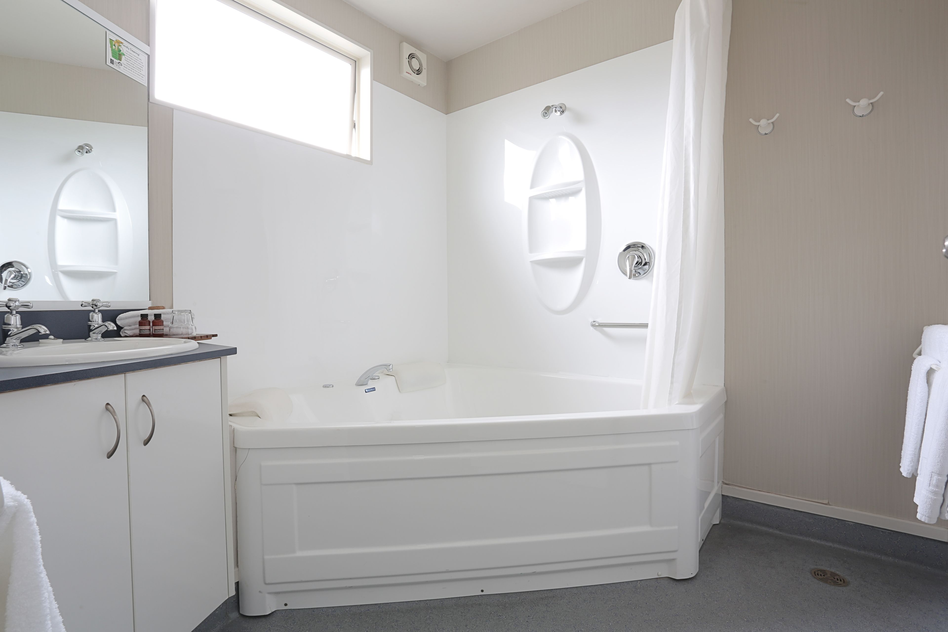 A bathroom with a bathtub, a sink, and a mirror.