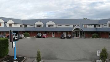 Un motel doté d’un parking central, de plusieurs entrées et d’un panneau indiquant la réception.
