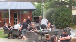 An outdoor patio area with wicker furniture and a barbecue grill. - Homestead Villa Motel (Invercargill)