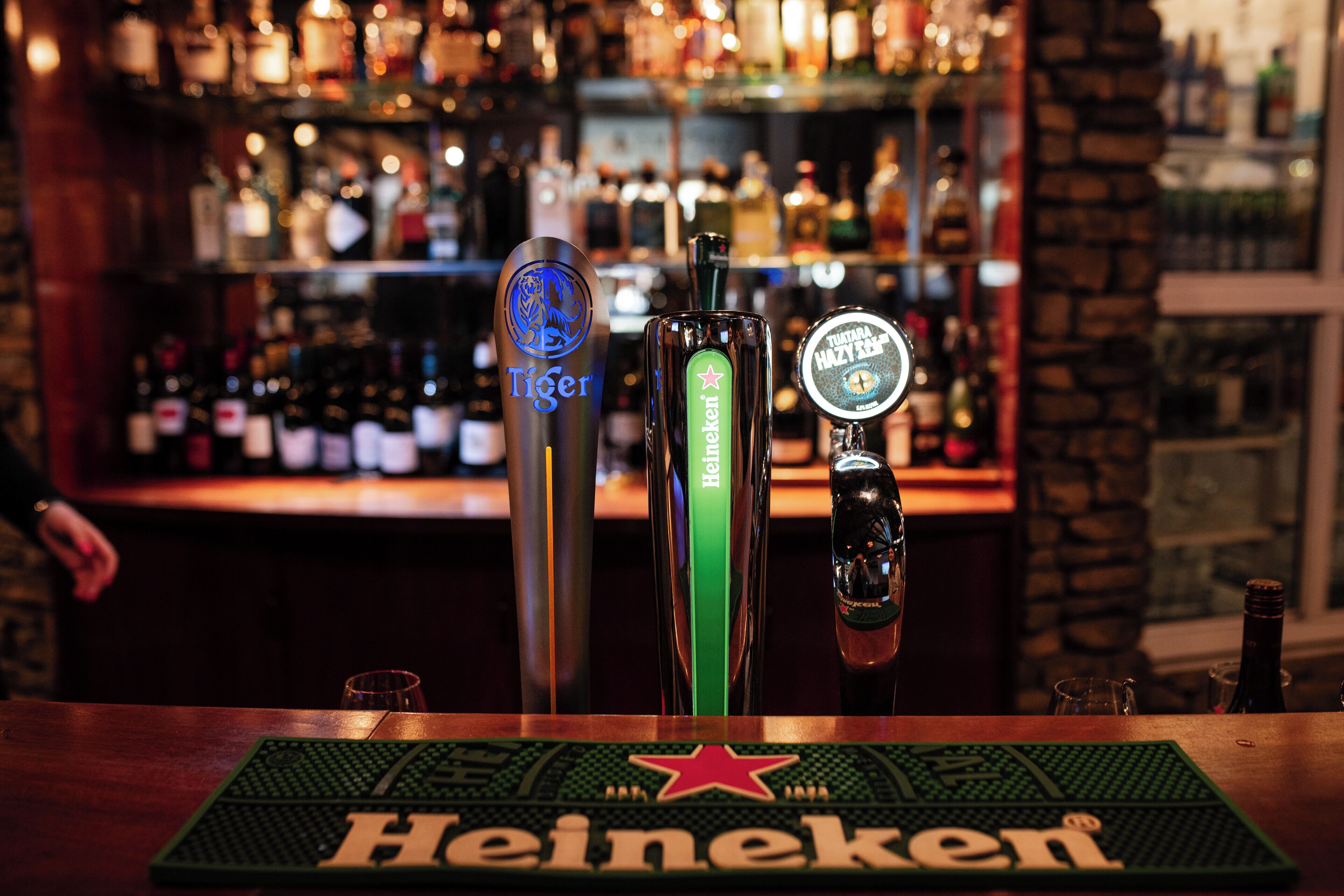 A bar with three taps labeled 'Tiger', 'Heineken', and 'Tytan'.