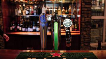 Un bar con tres grifos etiquetados 'Tiger', 'Heineken' y 'Tytan'.