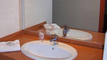 A bathroom with a white sink, a mirror, and a towel rack.