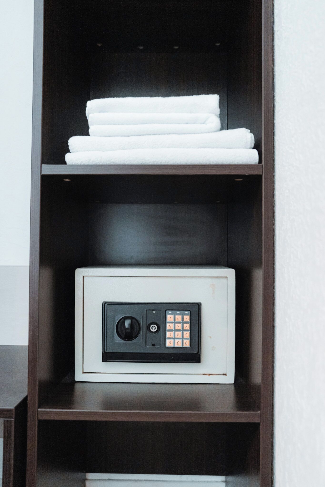 A white electronic device with a keypad on a shelf.