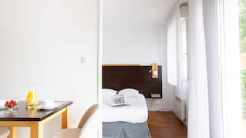Une chambre d’hôtel avec un lit, un bureau avec des articles pour le petit-déjeuner et un ordinateur portable.