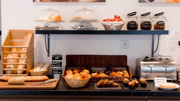 Un bufé de desayuno con panes, bollería y mermeladas variadas.