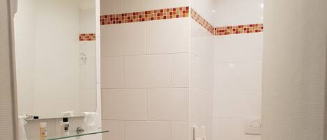 A bathroom with a white sink, mirror, and toilet.