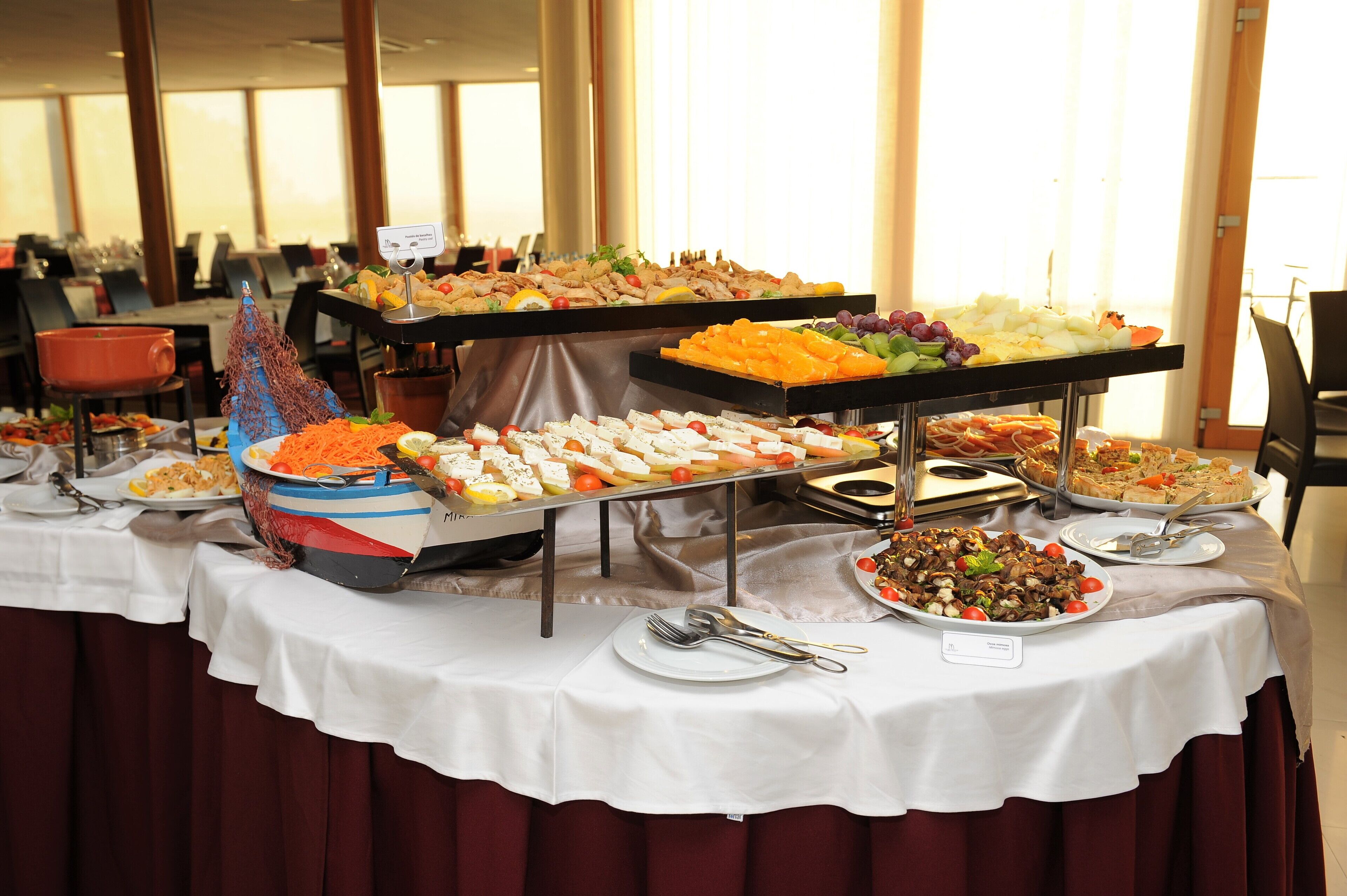 Una mesa de buffet con diferentes alimentos y utensilios.