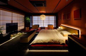 Ein modernes Schlafzimmer mit einem großen Bett, Nachttischen, einem Fernseher und einem großen Fenster mit Blick.