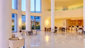 A spacious lobby with high ceilings, large windows, and a modern design. - Apollo Blue (Rhodes)
