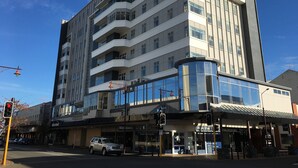 Un hôtel à plusieurs étages au design moderne, doté de balcons et de grandes fenêtres.