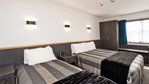A hotel room with two beds, a desk, a wardrobe, and a window with curtains. - Balmoral Lodge Motel (Invercargill)