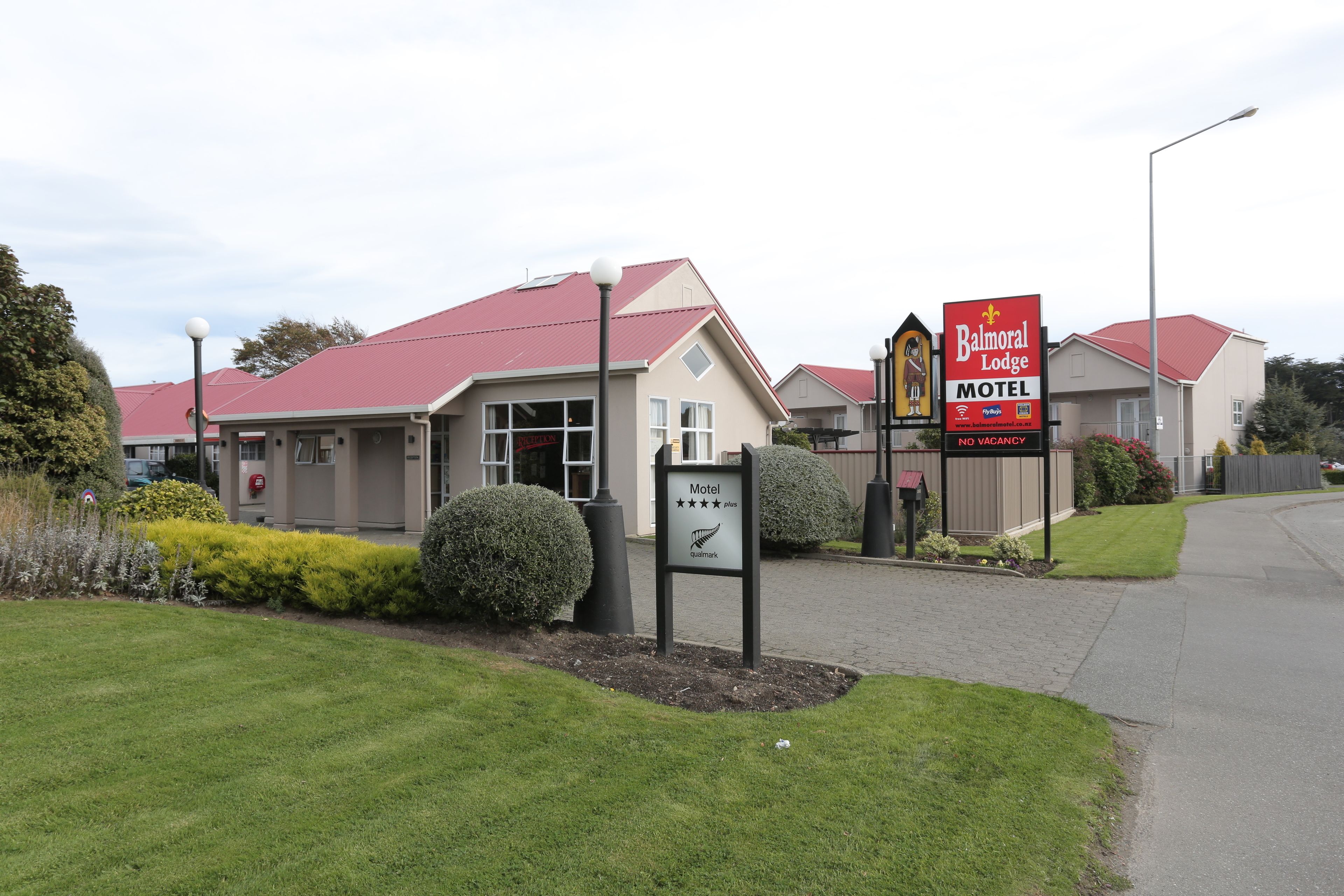 Ein Motel mit rotem Dach und einem Schild, das es als Balmoral Lodge Motel kennzeichnet.