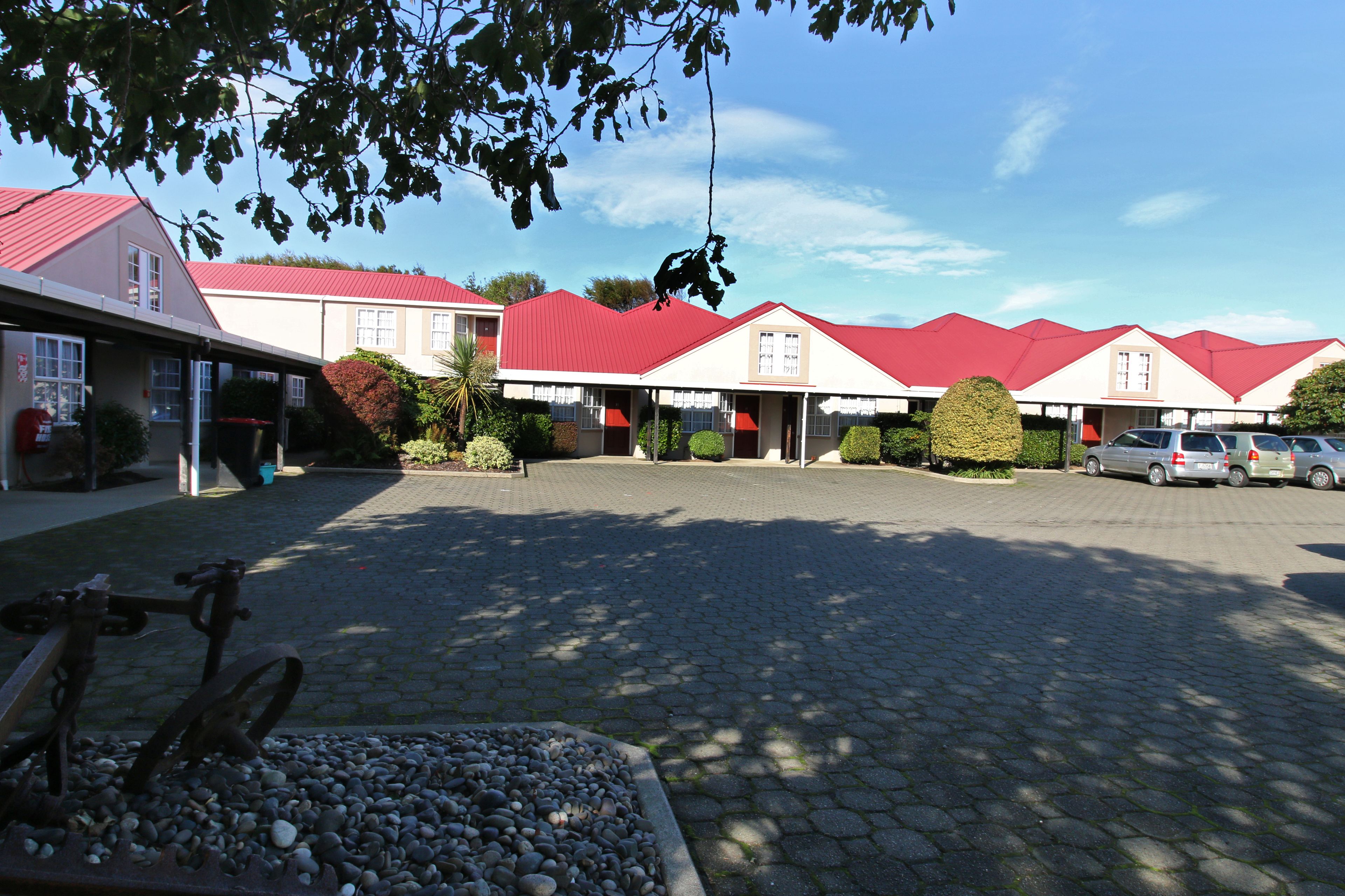 Ein Hotel mit roten Dächern und einem gepflasterten Innenhof.