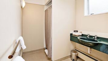 A bathroom with a sink, toilet, and shower curtain.