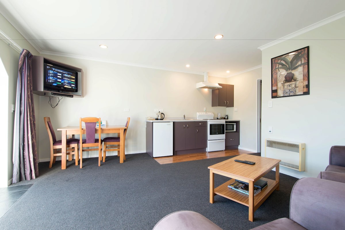 A compact living space with a kitchenette, a dining area, and a seating area.