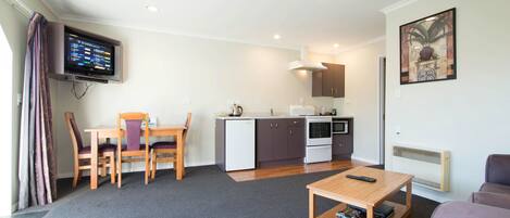 A compact living space with a kitchenette, a dining area, and a seating area.