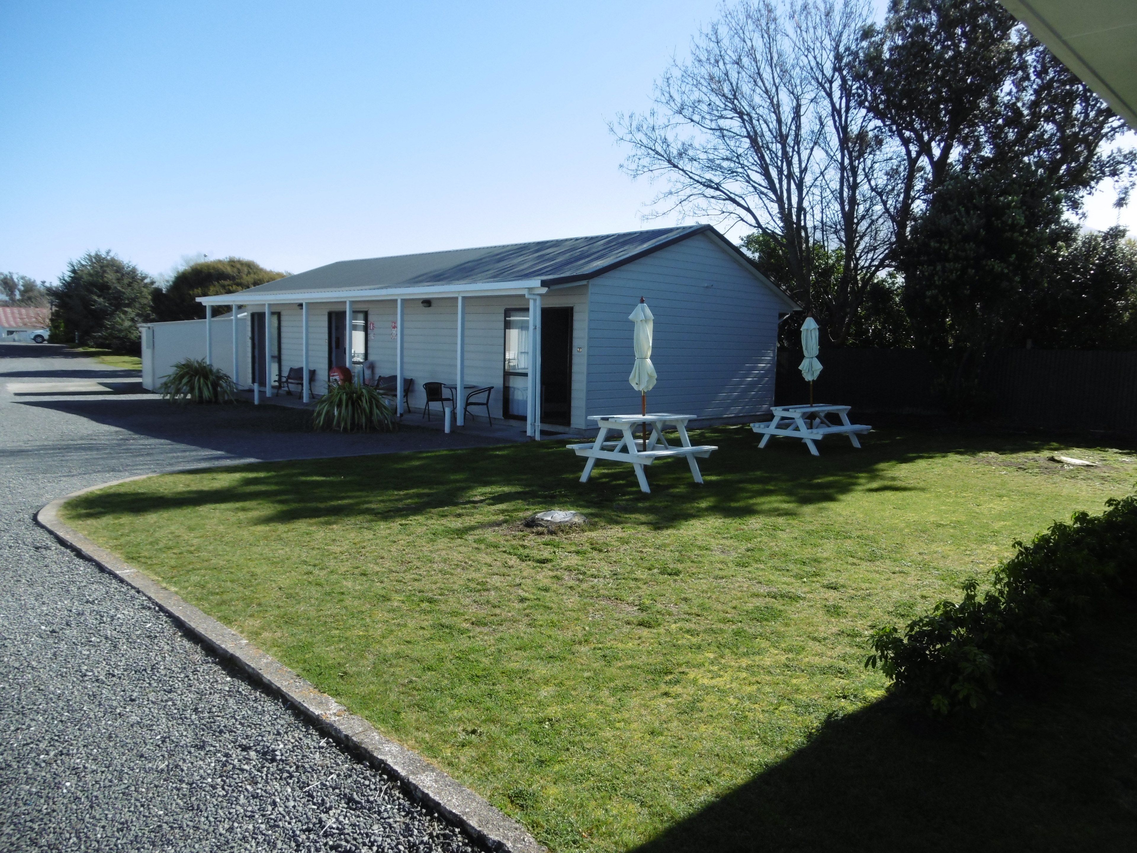 A small, single-story building with a covered porch and picnic tables.