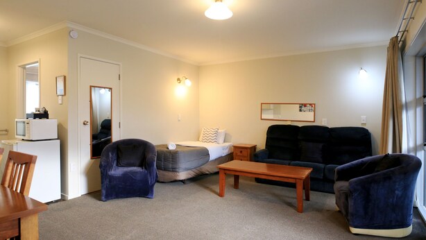 A furnished living room with a sofa, armchair, and a small table.
