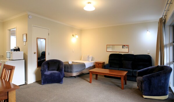 A furnished living room with a sofa, armchair, and a small table.