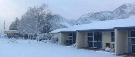 A building with a snow-covered landscape, including mountains in the background.