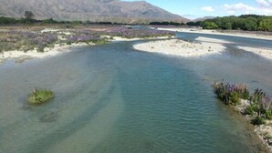 A river flowing through a valley with mountains in the background. - Ahuriri Motels (Omarama)