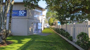 Un bâtiment avec une enseigne indiquant « plus de 50 chaînes » et une pelouse bien entretenue.