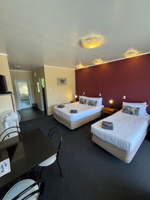 A hotel room with two beds, a dining table, chairs, and a TV. - Aldan Lodge Motel (Picton)