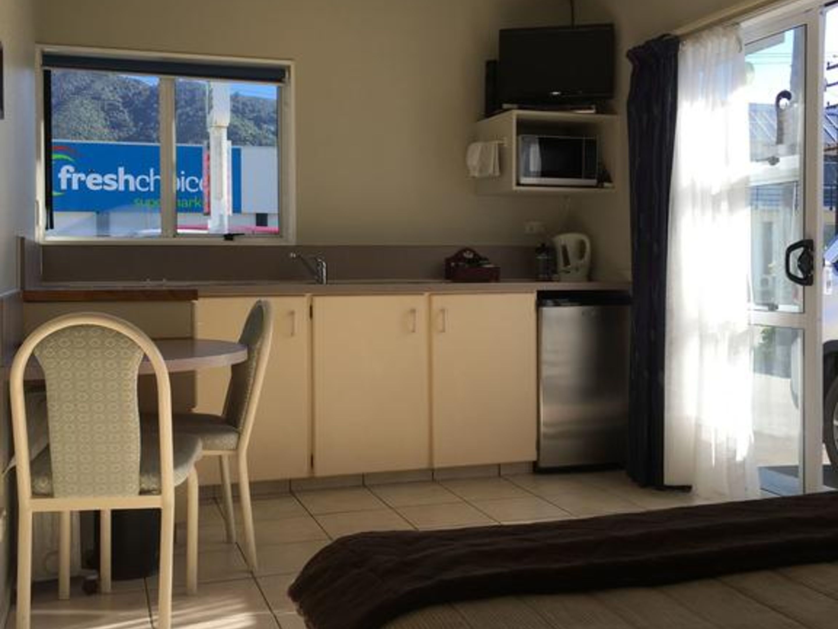 Cocina compacta con comedor, televisor y refrigerador.