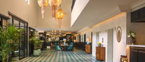 A spacious lobby with patterned flooring, a central seating area, and a decorative animal sculpture.