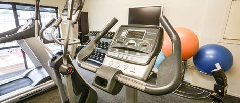 A gym with exercise equipment including a treadmill, an elliptical machine, and a stationary bike.
