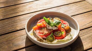 A bowl of Caprese salad on a wooden table.