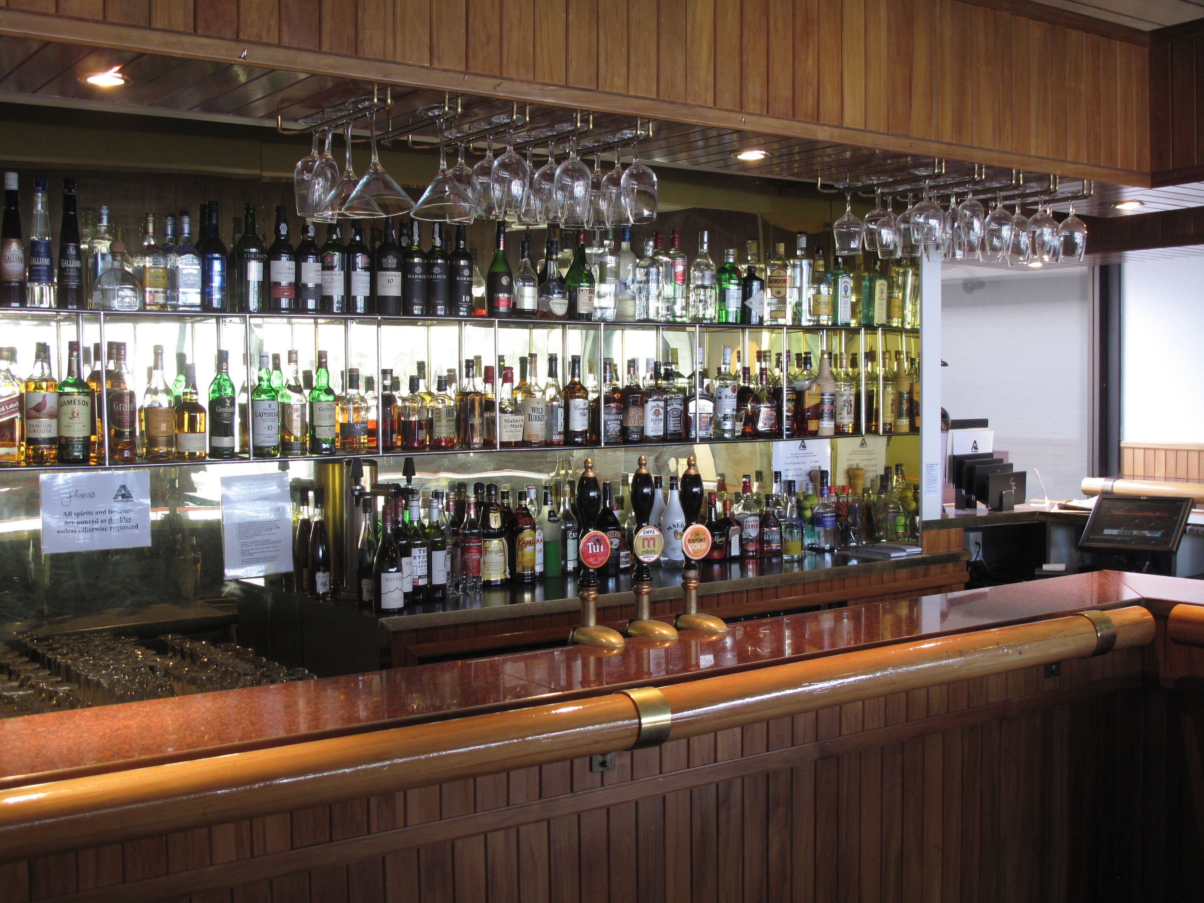 A bar with shelves of liquor bottles and a beer tap.
