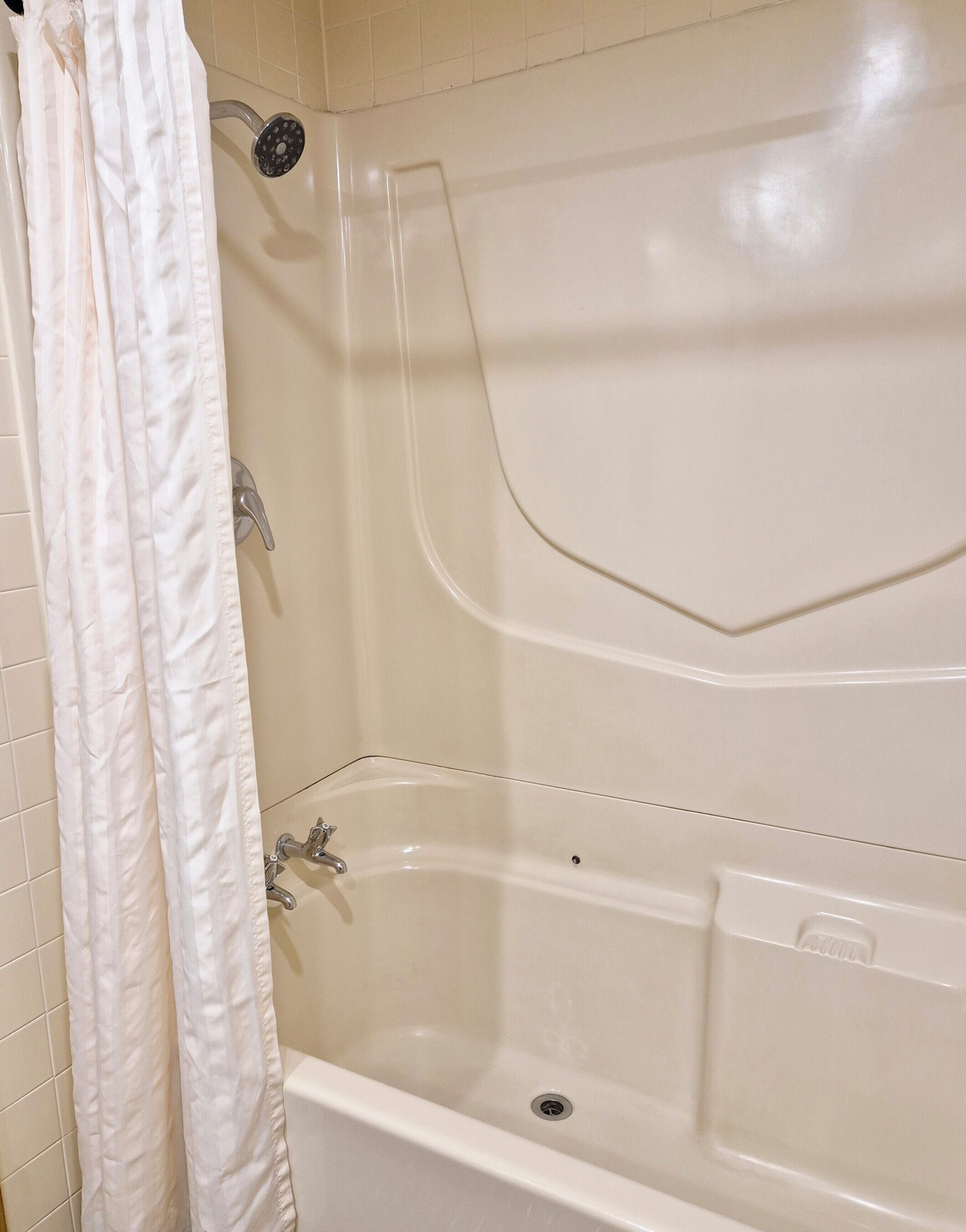 Un baño con bañera, ducha e inodoro.