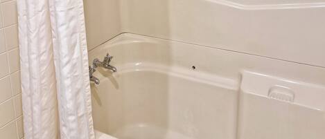 Un baño con bañera, ducha e inodoro.