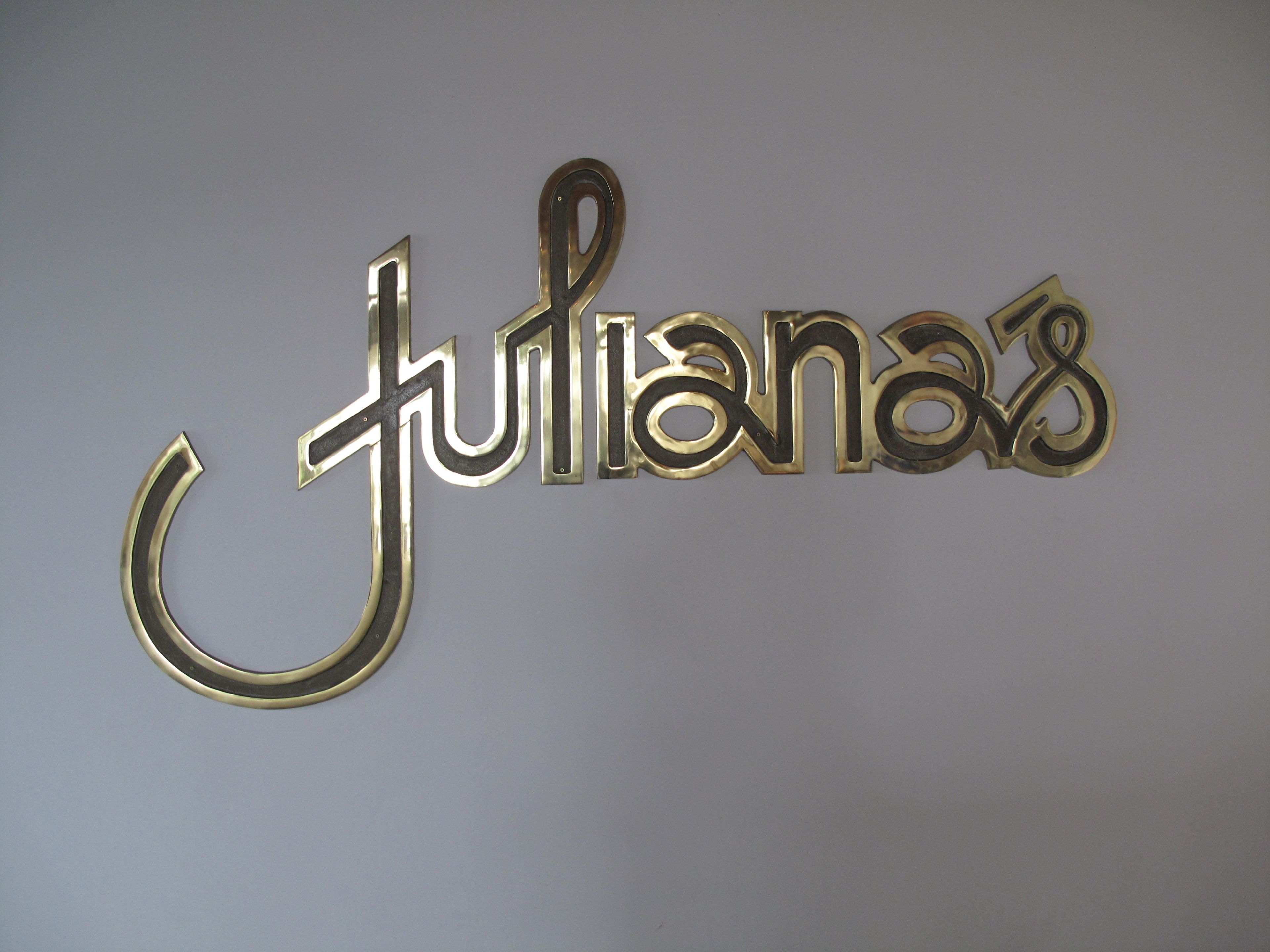 A wall-mounted sign with the name "Julianas" in a stylized font.