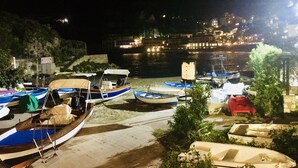 Vista nocturna de un puerto con barcos amarrados a la orilla.