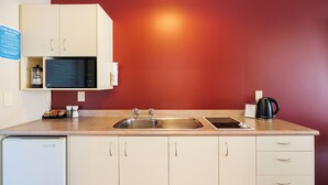 A kitchen with a sink, a coffee maker, and a microwave. - Braemar Motor Lodge (Palmerston North)