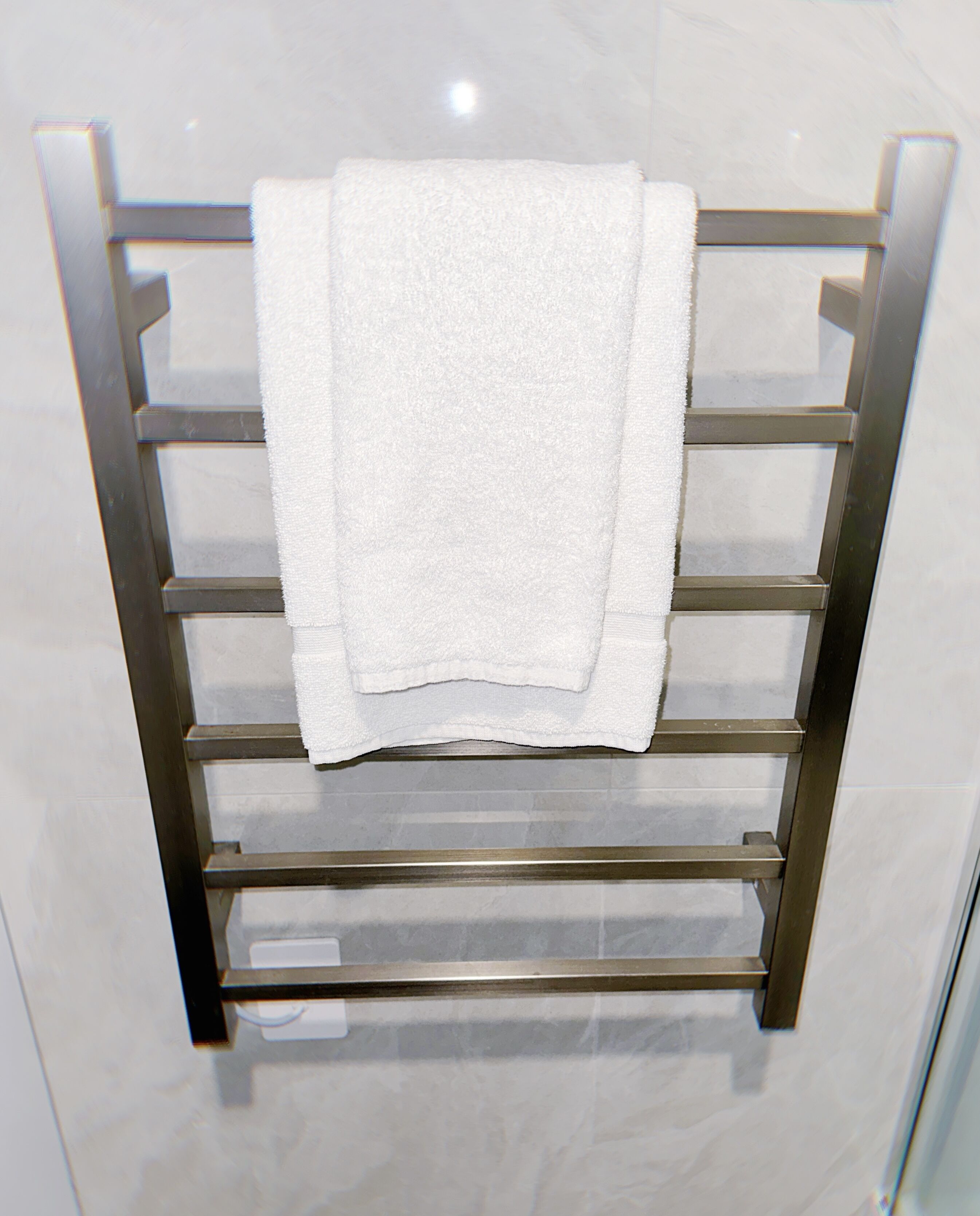 Un porte-serviettes métallique avec deux serviettes pliées.