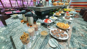 Un bufé con diversos alimentos, entre ellos pasteles, muffins y frutas.
