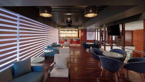 A modern lounge area with a bar, seating arrangements, and a view of the cityscape. - Best Western Plus Indore (Indore)