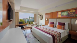A hotel room with a large bed, a desk, a chair, a TV, and a city view. - Best Western Plus Indore (Indore)