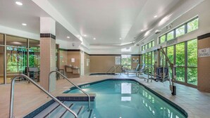 Piscina interior com marcações claras de profundidade, avisos de segurança e salva-vidas de serviço.