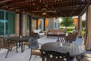 Un patio al aire libre con una mesa redonda, sillas y un sofá.