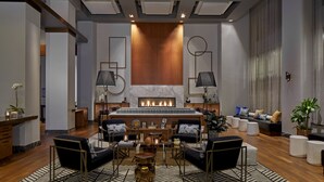 A modern hotel lobby with a fireplace, seating area, and a reception desk. - Renaissance Atlanta Midtown Hotel (Atlanta)