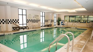An indoor swimming pool with clear pool rules and no lifeguard on duty signs, surrounded by lounge chairs and a seating area. - Hampton Inn North Brunswick / New Brunswick (North Brunswick)
