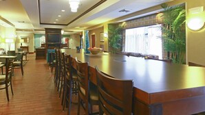 A spacious hotel lobby with a long reception desk, multiple seating areas, and a large window with a view of the outdoors. - Hampton Inn North Brunswick / New Brunswick (North Brunswick)
